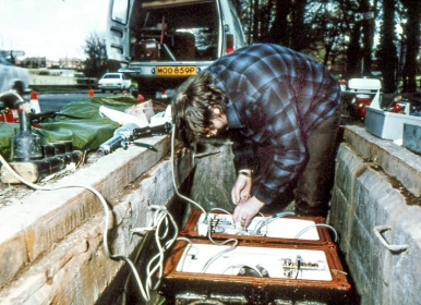 Photo of engineer aligning optical connectors on a regenerator